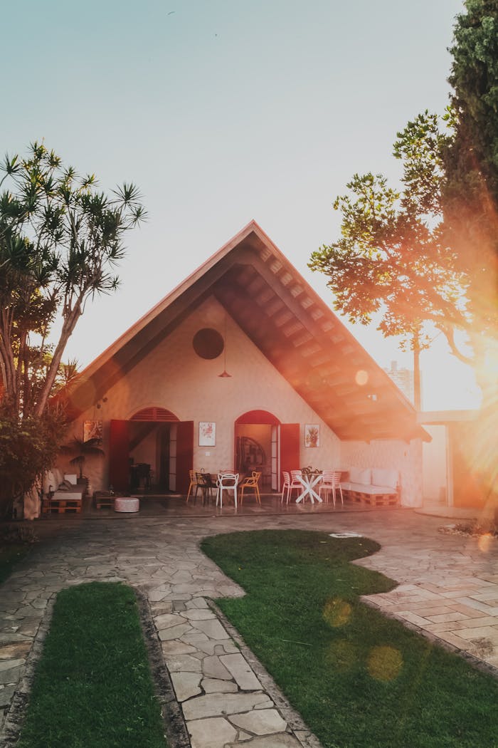 Crafting Captivating Headlines: Your awesome post title goes here Beautiful A-frame house surrounded by lush garden in warm sunlight, creating a serene and inviting atmosphere.